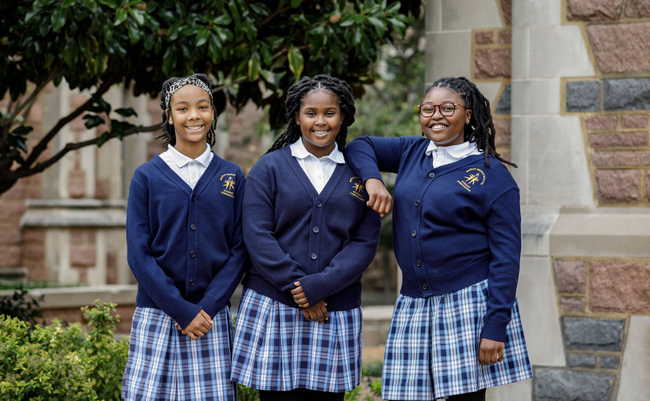 Three students from Marian Middle School pose in their uniforms.