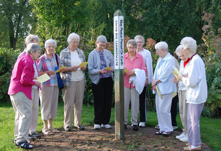 Sisters gathered around the Peace Pole for the Pax Christi Prayer. The pole has "May Peace Prevail On Earth" written in English, German, Spanish, Hmong, Lakota and Swahili to represent places sisters have served. 