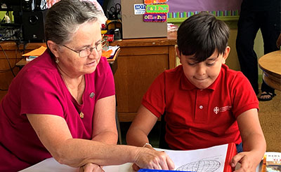 Rising Star in Milwaukee helps students through tutoring. Sister Sylvia Hecht tutors a student to at Notre Dame Middle School.